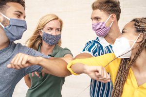 Group of masked people touching elbows